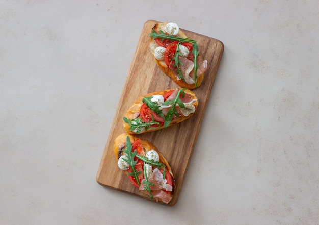 Foto bruschetta met ham, mozzarella, tomaten en rucola. wijn voorgerecht. snack.