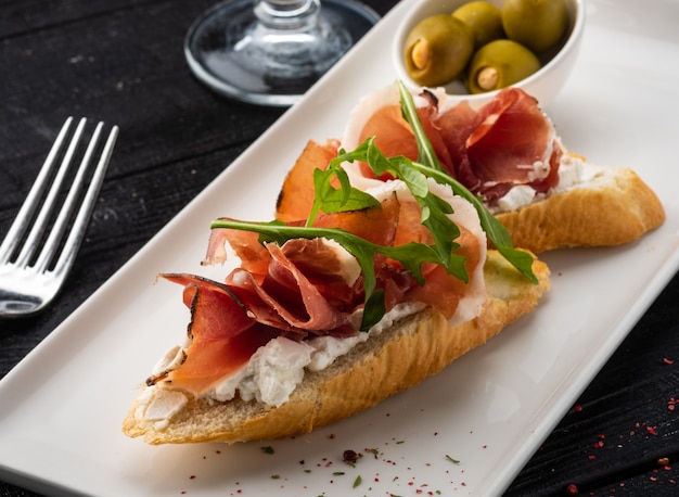 Bruschetta met Parma en geitenkaas, olijven en amandelen. Wijnset