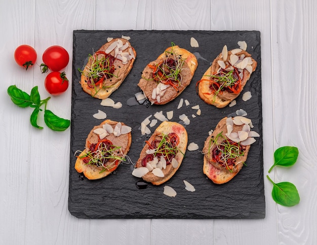 Bruschetta met paté en gekarameliseerde uien op een stenen bord