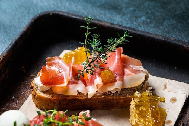 Bruschetta met prosciutto en pestosaus op bord Bruschetta met hamon-meloen en honing Spaans voorgerecht Italiaanse antipasti
