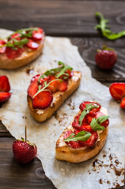 bruschetta met roomkaas, aardbei, rucola en balsamicoazijnsaus met honing. c