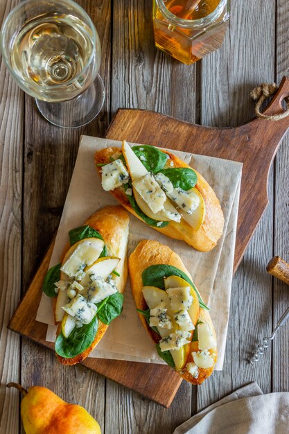 Bruschetta met spinazie, peer en blauwe kaas. wijn. vegetarisch eten. gezond eten. veganisme. eetpatroon.