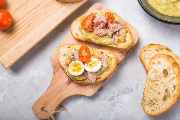 Bruschetta met spread van tonijn, tomaat, ei en avocado.