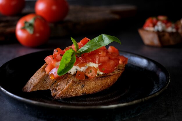 Bruschetta met tomaat, basilicum en dorp kaas op een houten bord met tomaten tafel. Traditionele Italiaanse voorgerecht of snack