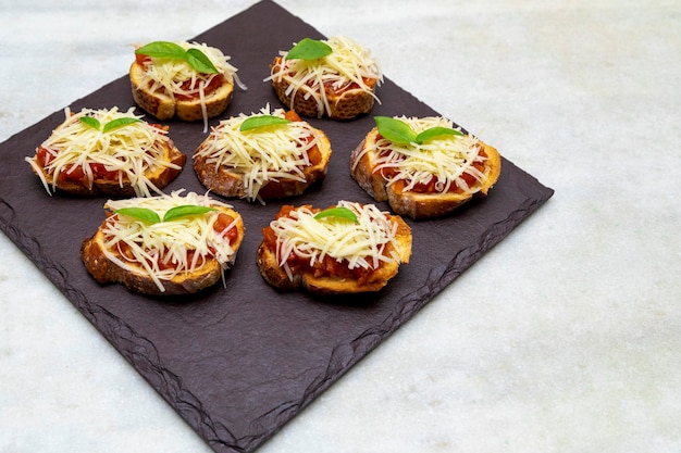 Bruschetta met tomaat, basilicum en mozzarellakaas op houten bord