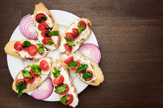 Bruschetta met tomaten, kaas, uien en peterselie