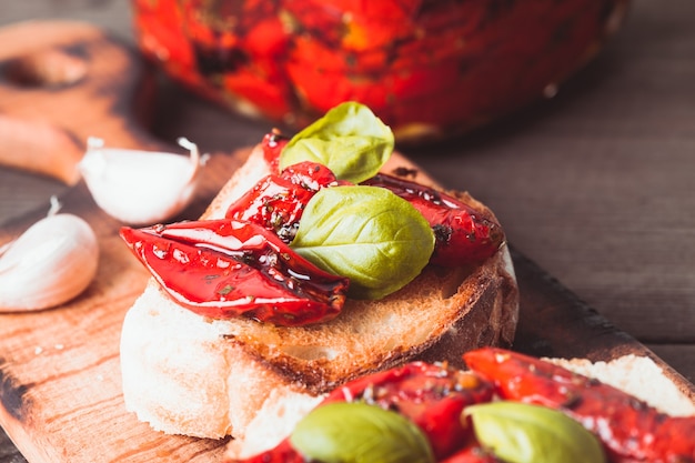 Bruschetta met zongedroogde tomaten, basilicumblaadjes en knoflook