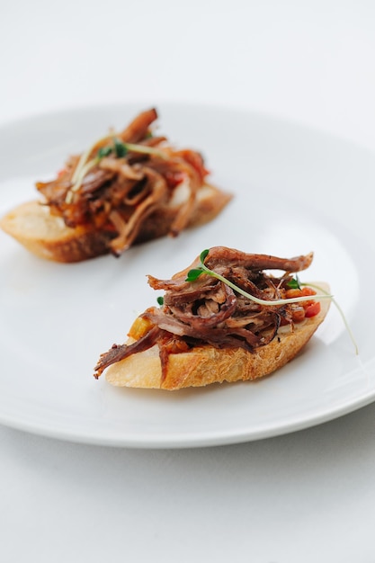 Bruschetta op een bord close-up over wit Gemarineerde vis wit brood en plantenbouillon