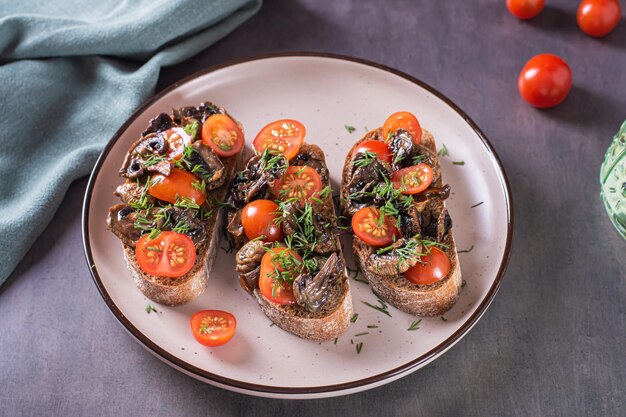 Bruschetta on rye ciabatta with cherry tomatoes and fried mushrooms on a plate