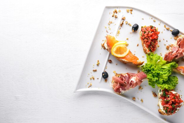 Bruschetta Sandwich with salmon and hamoon On a wooden background Top view Free space