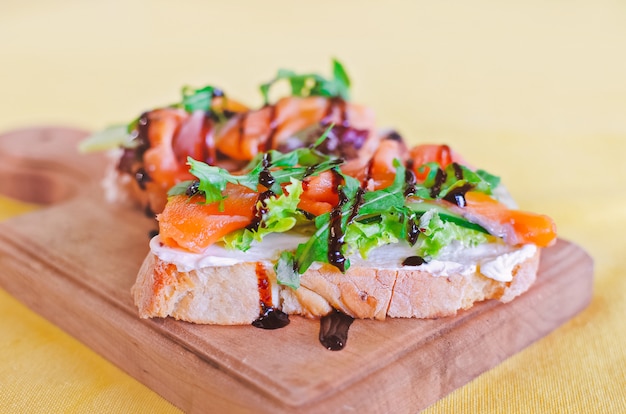 Bruschetta sandwiches with salmon and arugula