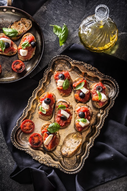 Bruschetta toast met mozzarella tomaten olijven basilicum en olijfolie Italiaanse keuken