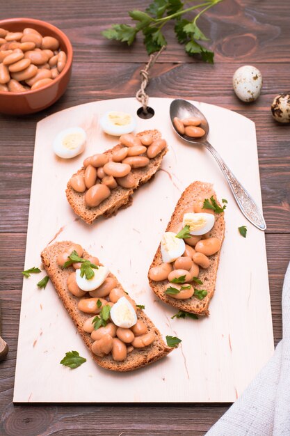 Bruschetta with boiled beans on a cutting board