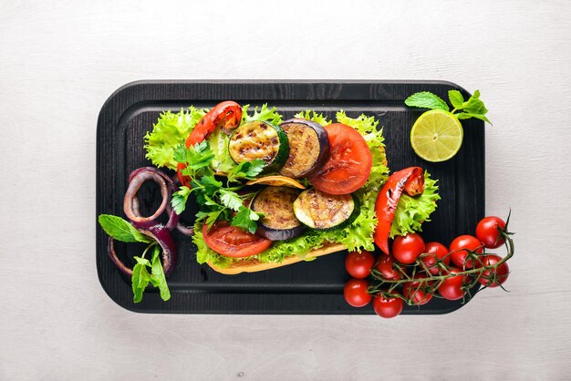 Bruschetta with grilled vegetables olives herbs and parmesan cheese on bread Cold snacks Italian cuisine On Wooden background