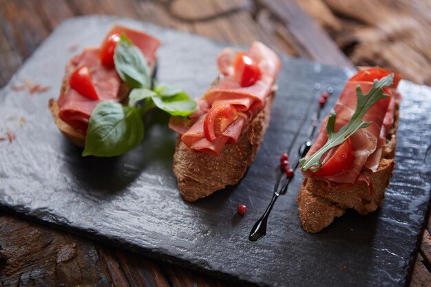 Bruschetta with hamon and sauce on black stone