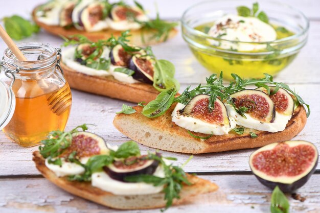 Bruschetta with mozzarella, arugula and figs, seasoned with honey and spices