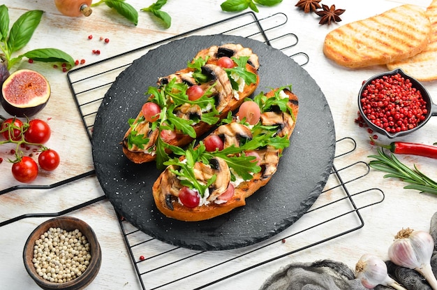 Bruschetta with mushrooms arugula grapes and feta cheese Free space for your text Top view