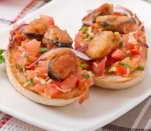 Bruschetta with mussels, cheese and tomatoes