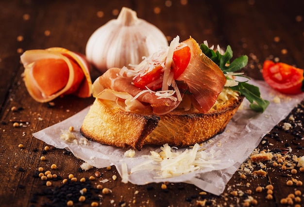 Bruschetta with prosciutto tomatoes arugula and parmesan cheese