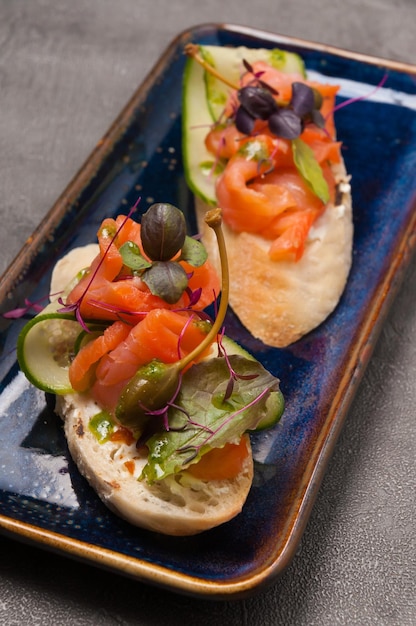 Bruschetta with salmon cucumber and capers is a great snack Closeup Vertical photo