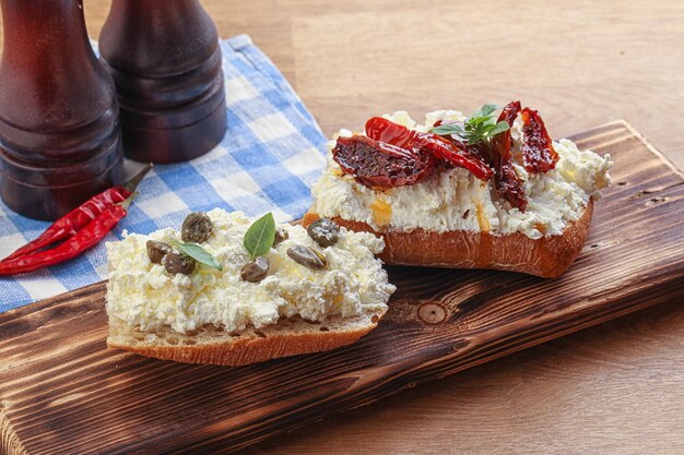 Foto bruschetta con cappelli di formaggio morbido e pomodoro