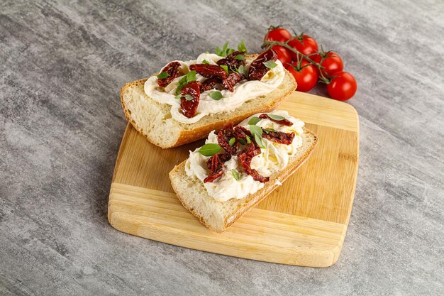 Photo bruschetta with strachatella cheese and dry tomato