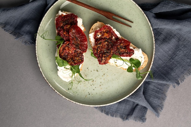 Bruschetta con pomodori secchi crema di formaggio e verdure fresche cibo sano e genuino servire il cibo in un ristorante foto per il menu