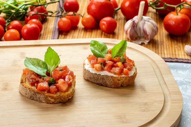 Bruschetta with tomato ricotta and basil on a wooden board