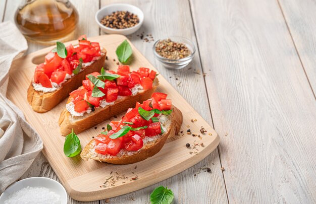 Bruschetta with tomatoes feta and basil on a beige background