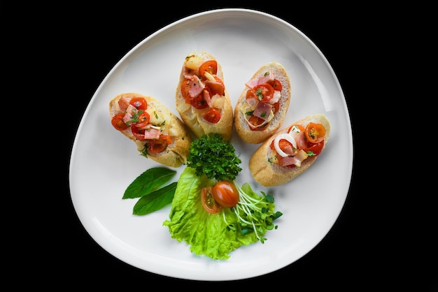 Bruschetta with tomatoes hamonion and olive oil on white plate close up