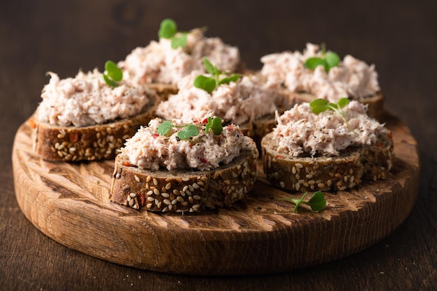 Bruschetta with tuna pate fish rillettes on wooden background selective focus