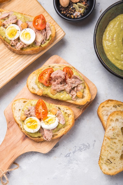 Bruschetta with tuna, tomato, egg, and avocado spread.