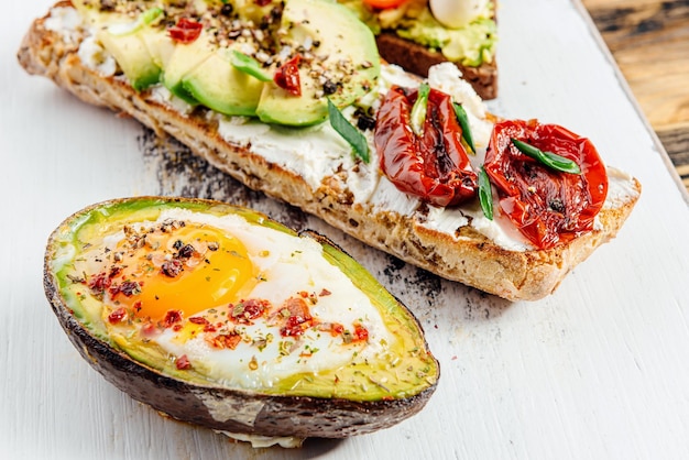 Bruschettas with avocado and avocado with egg healthy breakfast