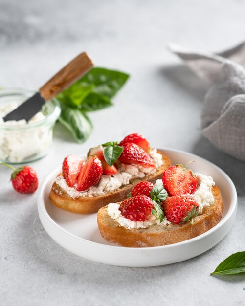 Bruschettas with strawberries, cream cheese, and basil