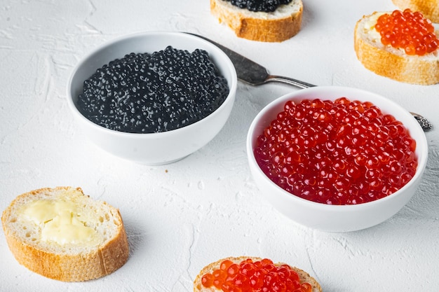 Bruschettes with butter red, and black caviar, on white background