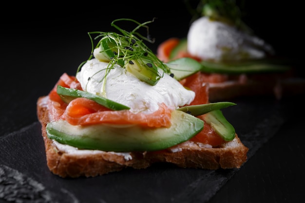 Bruschettes with salmon, avocado, cream cheese and poached egg