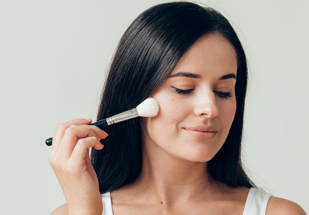 Brush  makeup woman face healthy skin natural make up powder. Studio shot.