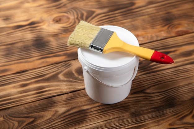 Brush on the paint bowl on the wooden table
