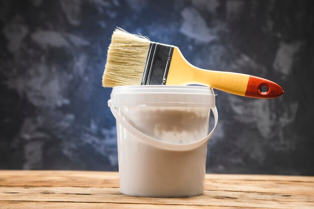 Brush on paint bowl on wooden table