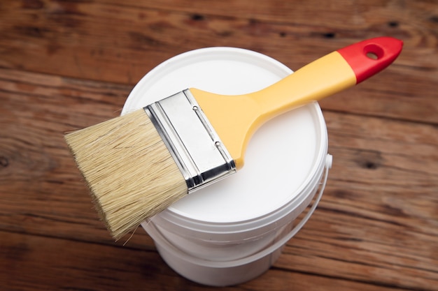 Brush on the paint bowl on the wooden table