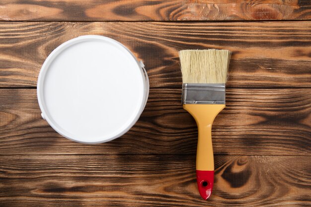 Photo brush on the paint bowl on the wooden table