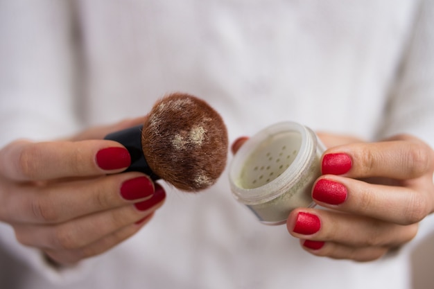 Brush and powder in female hands