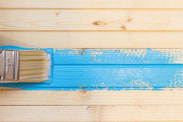 Foto colpo di pennello con pennello blu su assi di legno