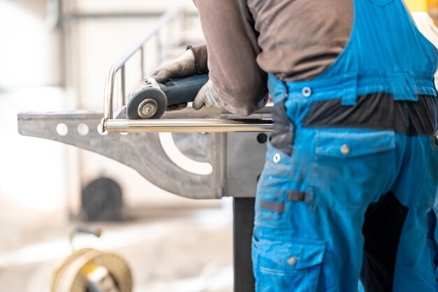 Brushed stainless steel a man in blue overalls is working on a machine in a factory