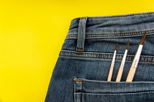 Brushes in the back pocket of blue women's jeans