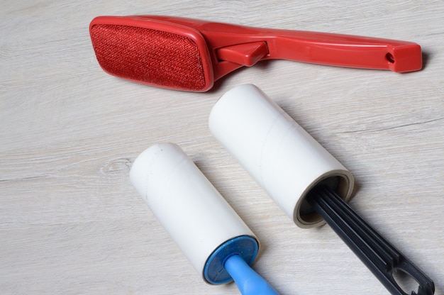 Brushes for cleaning clothes. sticky and a bristled brush, lie on a light-colored countertop.