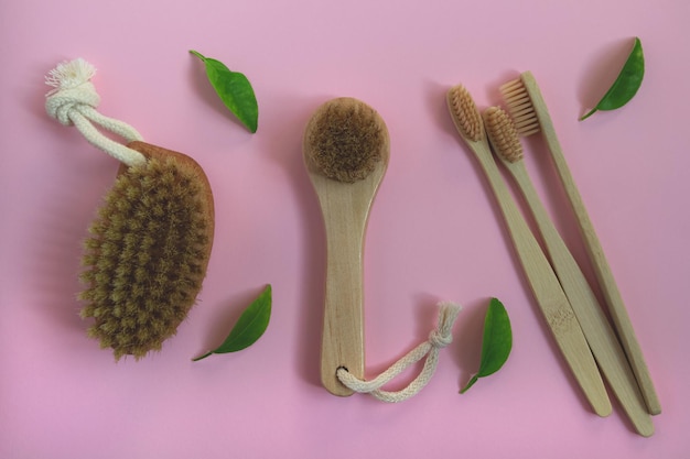Brushes for dry lymph massage and toothbrushes made of natural materials Ecofriendly personal hygiene products on a pink background
