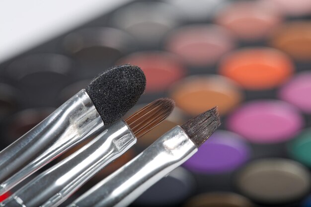 Photo brushes kit. closeup. makeup palette of eye shadows in the background.