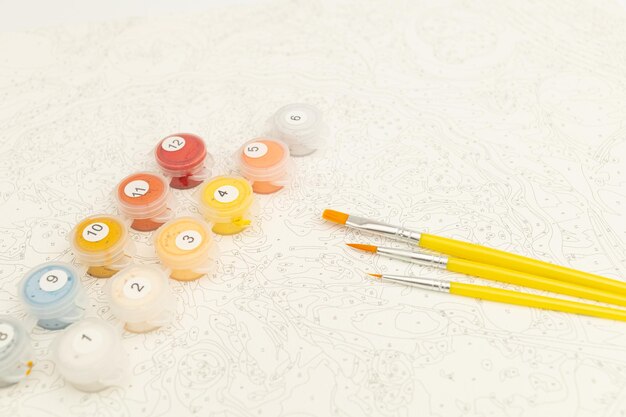 Brushes for painting yellow on white canvas