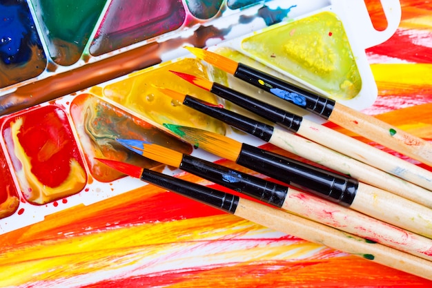 Brushes and paints for drawing in composition on the table